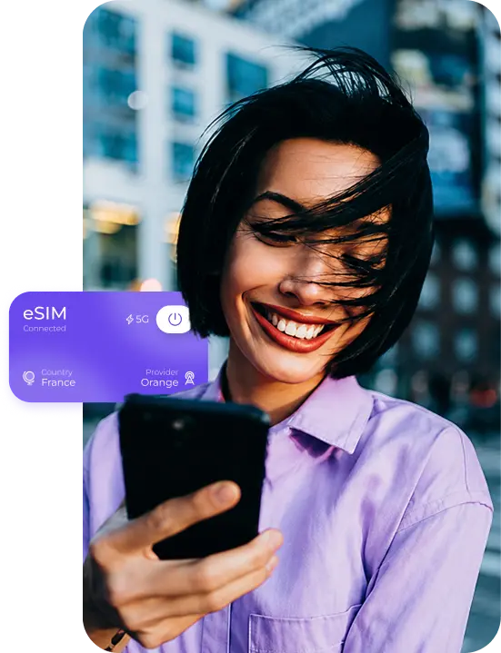 Viajera sonriendo a su teléfono con una eSIM de SLYNUMBER conectada en Francia